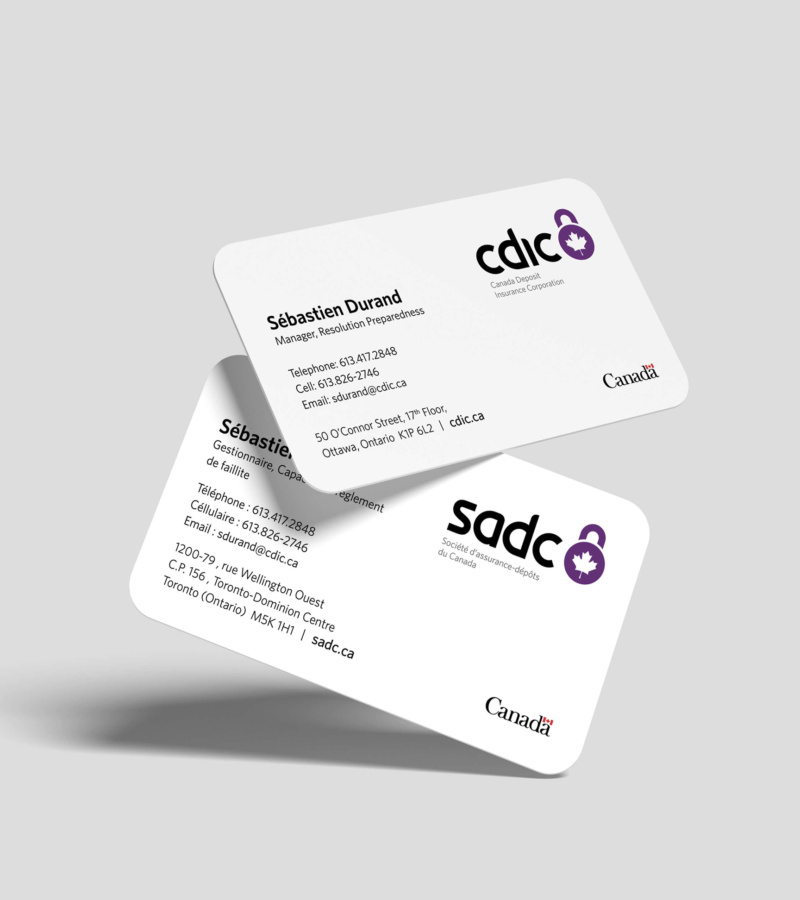 Two CDIC business cards on a grey background, showing bilingual layouts with purple lock logo and Canada wordmark.