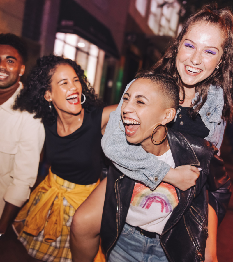 Group of friends laughing and having fun together on a night out.