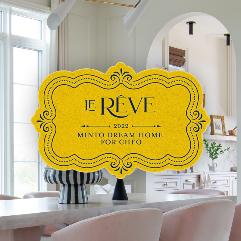 Yellow ornate sign reading “Le Rêve, 2022 Minto Dream Home for CHEO” inside a bright kitchen.