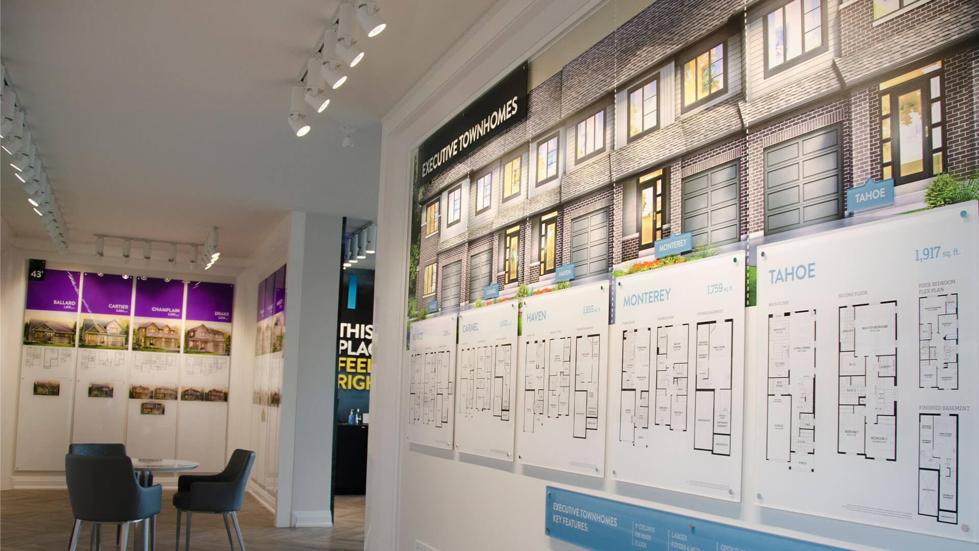 Interior of the Minto Quinn's Point sales centre showcasing townhome renderings and floor plans with bright lighting and modern display panels.