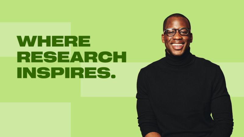 Smiling man in black turtleneck on green background with text “Where Research Inspires.”