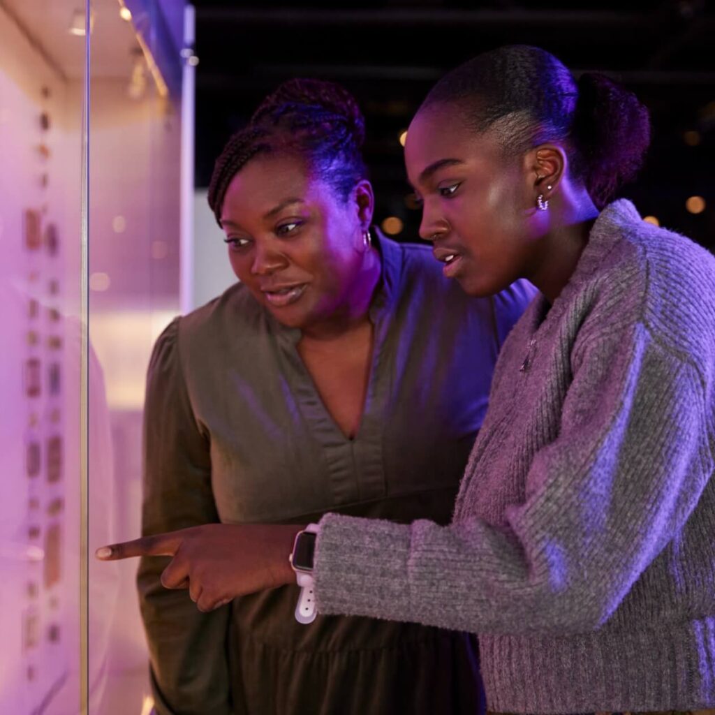 two people looking at artifacts in a museum with wonder
