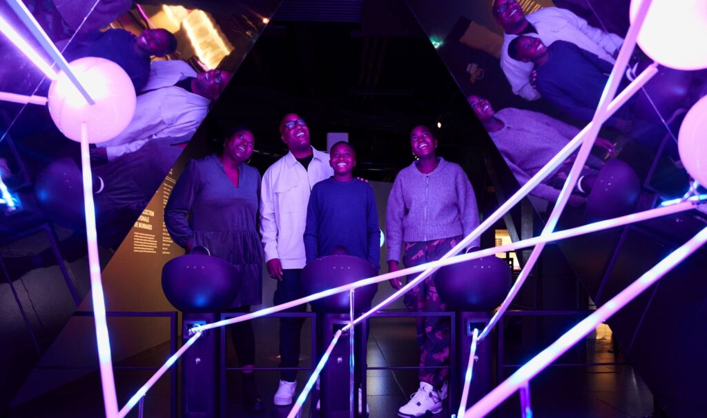 musuem patrons are having fun and laughing in a crazy mirror room